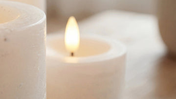 weiße led-kerzen mit 3d-flamme auf holztisch im warmen wohnzimmer