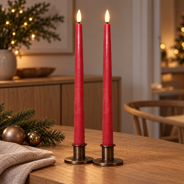 Rote LED-Stabkerzen in Bronzekerzenhaltern mit Tannenzweigen und Christbaumkugeln als Weihnachtsdeko